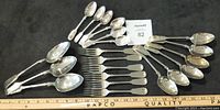 Photo showing all silverware pieces laid out on a flat surface with a ruler for scale.