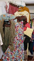 Photo showing various ladies dresses, tops, pants including floral and solid colors, highlighting texture and pattern detail