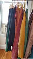 Hanging leather skirts and jackets in various colors including turquoise, mustard, rust, maroon, green, and black.