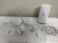 Photo showing the full set of items including one base station, two satellite mesh nodes, three power adapters, and Ethernet cable.