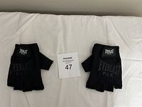 Pair of black Everlast F.I.T. fingerless gloves placed palm down on light surface, showing logo on backs.
