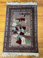 Area rug showing full view with map of Aran and weapon depictions, fringed edges, and decorative border