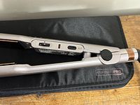 Close-up photo of the straightener showing control switches and the heat mat underneath.