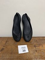 Front view of both black Crocs slip-on sandals showing size label 38 in front.