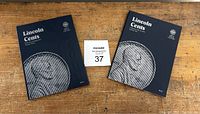 Two blue coin collection books titled 'Lincoln Cents' placed side by side on a wooden surface.