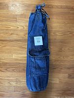 Denim carrying bag for yoga mat showing pocket and drawstring closure