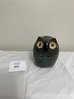 Front view of ceramic owl statue with detailed face and textured body, showing height and appearance.