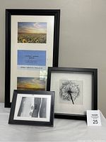 Photo showing three black picture frames of different sizes arranged together against a wall.