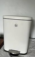 Front view of small white trash can showing clean surface and pedal.
