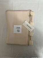 Folded beige waist shapewear with Yianna tag and multiple hook closures visible
