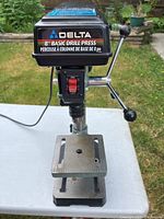 Full front view of Delta 8 Basic Drill Press with visible on/off switch and logo.