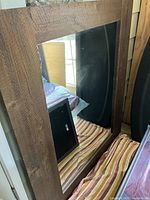 Mirror front showing rustic rough wood frame and reflective glass surface