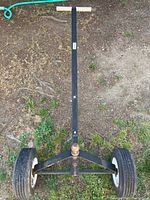 Top view of manual boat trolley showing frame, wheels, and wooden handle