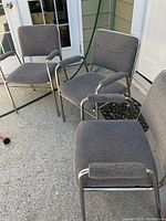 Three gray upholstered metal-frame office chairs, showing overall view with seats, backs and armrests visible