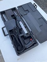 Overview of Craftsman reciprocating saw stored inside black carrying case with power cord coiled.