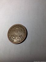 Reverse side of 1943 Newfoundland penny featuring floral motif and year split, with inscriptions.