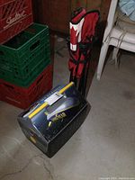 Photo showing the cooler and red folding chair against a concrete floor and plastic crates.