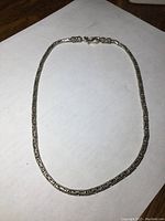 Full view of the 18 inch sterling silver chain laid out flat on a white surface showing length and clasp.