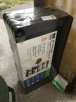 Photo of sealed wrapped KIS 36x18x72 resin shelving box from front side showing packaging and label.