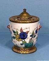 Front view of the Limoges porcelain inkwell showing floral decorations and gilt brass lid.