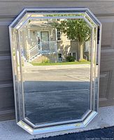 Front view of large hexagonal Bowring Cecilia mirror leaning against wall outdoors, showcasing full mirror and frame.