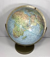 Front side view of the vintage Reader's Digest Great World Globe showing Africa and surrounding regions, metal base and meridian ring visible.