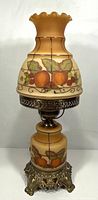Lamp unlit showing painted fruit design and ornate metal base