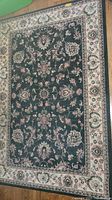 Full rectangular rug showing dark blue center with floral pattern and beige floral border.