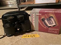 Photo showing Bushnell Powerview 9-27x25 binoculars with original box and carrying case, Lot #165 label visible