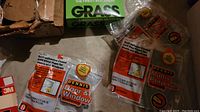 Photo showing weatherstrip packaging labeled Dennis Door & Window and Multi-Purpose weatherstrip, with green box of landscaping grass and loose wire.