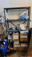 Full view of the metal shelving unit showing the three shelves and items placed around it