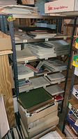 Side view of gray metal shelving unit loaded with various papers and boxes