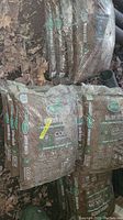 View of several bags of Scotts Earthgro Brown Mulch stacked outdoors on the ground among leaves, showing the full branding and product details.