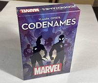 Front angled view of sealed Codenames Marvel Edition box showing artwork with Marvel hero silhouettes.