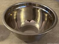 Side angled view of the 12-inch stainless steel mixing bowl showing the smooth, reflective interior and flat base.