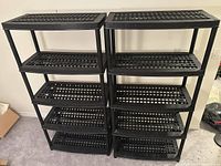 Front view of two assembled black resin shelving units side by side, each with 5 shelves.