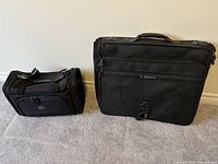 Photo showing both the Samsonite garment bag and carry-on bag side by side on a carpeted floor against a white wall.