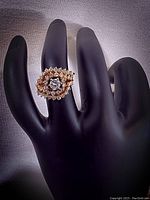 Overhead view of stacked solitaire ring and duo of curved enhancer bands on black display hand