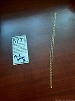 Full view of 14k gold rope chain laid out next to lot sticker