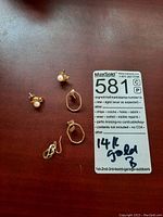 All five earrings displayed together including two pairs and one single earring.