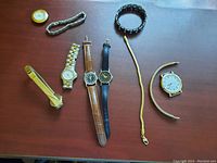 Top view of all nine items spread on a table showing watches and bracelets.