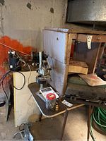 Wide view of Craftsman drill press on a work table with various loose parts and accessories including screws in a jar.