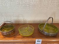 Three vintage Vaseline uranium glass divided dishes, two with ornate metal holders and one plain glass dish. Yellow-green glass with starburst base and three compartments.
