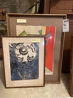 Both framed prints leaning against shelving