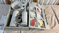 Braun Multipractic Deluxe hand blender set in original box with parts visible, shows motor unit, bowl and blending attachments