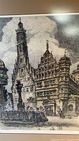 Close-up of the print showing the town square and cathedral style buildings with a tall tower, group of people in the foreground, and detailed architectural elements.