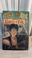 Front cover of the book showing Harry Potter with his wand, title, and author's name (J.K. Rowling).