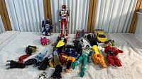 The full collection on display with various toy robots and figures in multiple colors, some assembled and others in parts