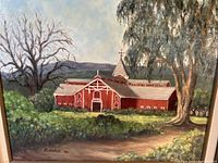 Close-up photo of signed painting showing red farmhouse scene