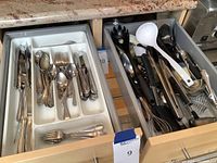 Drawer with assorted cooking utensils such as pizza cutter, ladles, spatulas, ice cream scooper, and garlic press